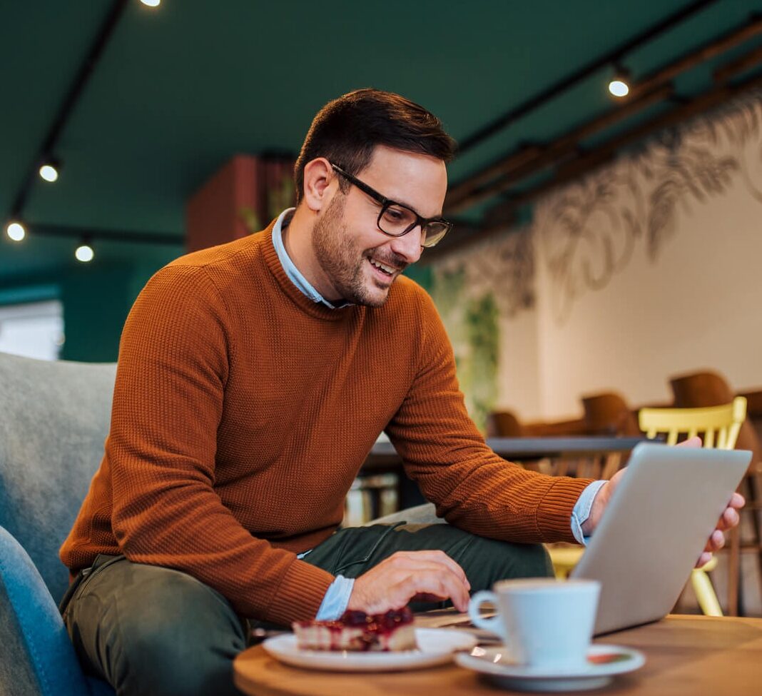 cheerful man using laptop in a cozy restaurant po 2024 10 18 07 51 26 utc 1 1 cropped.jpg